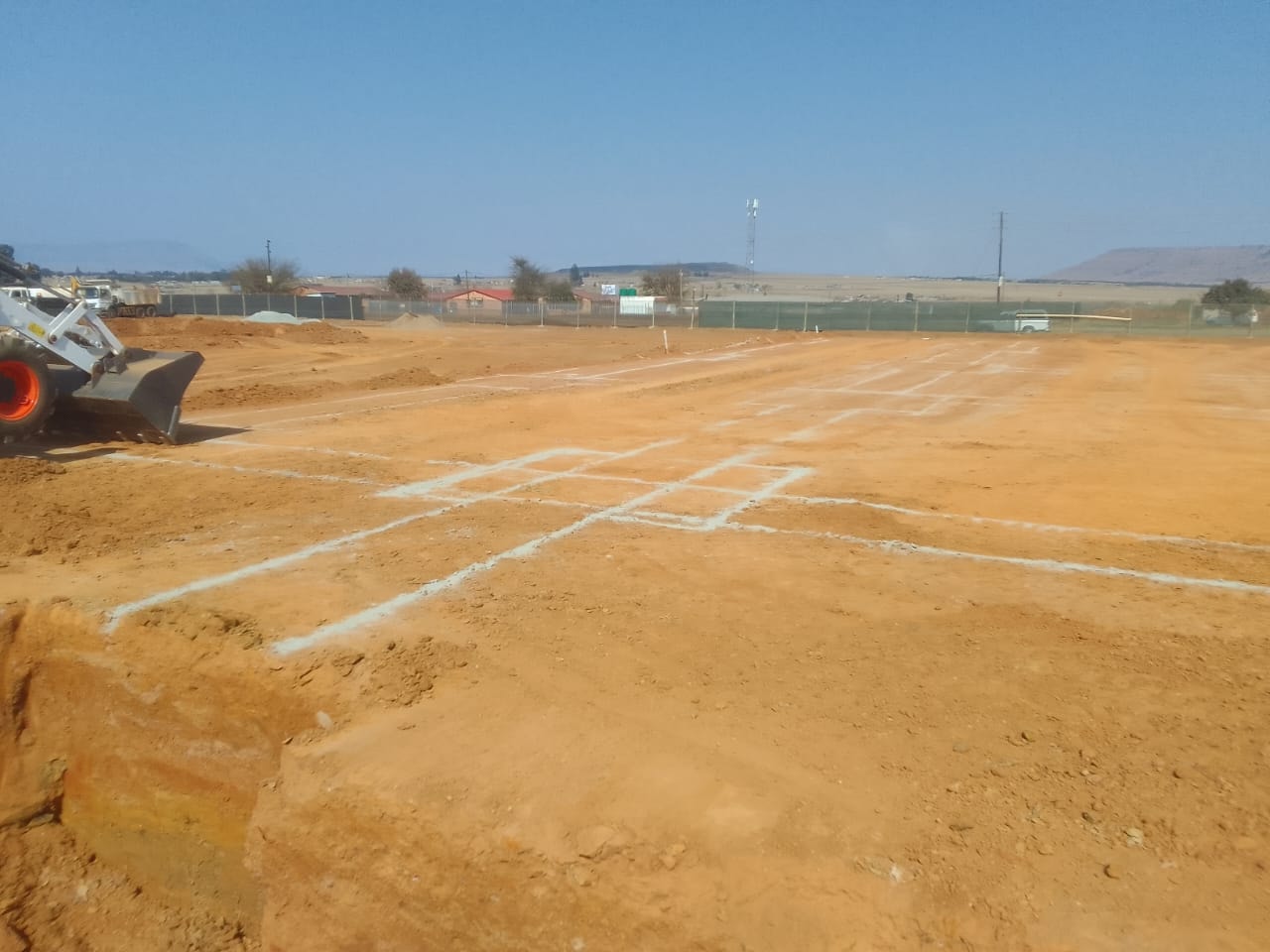 Bobcat marking out foundation grid lines at Three Fountains Mall site