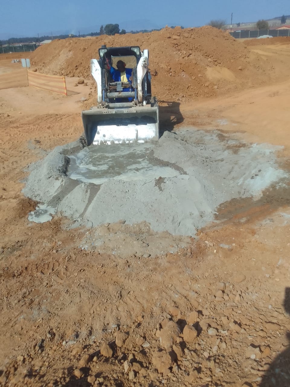 Bobcat spreading concrete on the Three Fountains Mall construction site