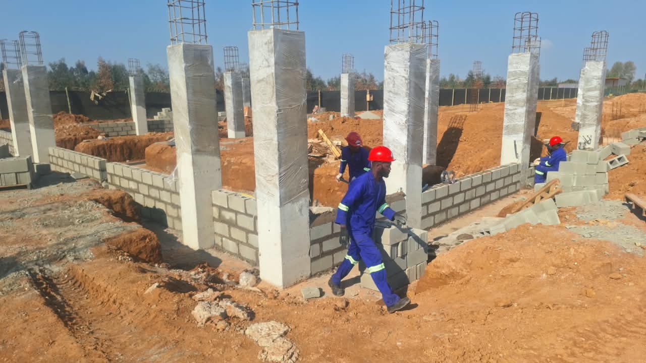 Workers laying foundation blockwork between concrete columns at Three Fountains Shopping Centre, September 2026